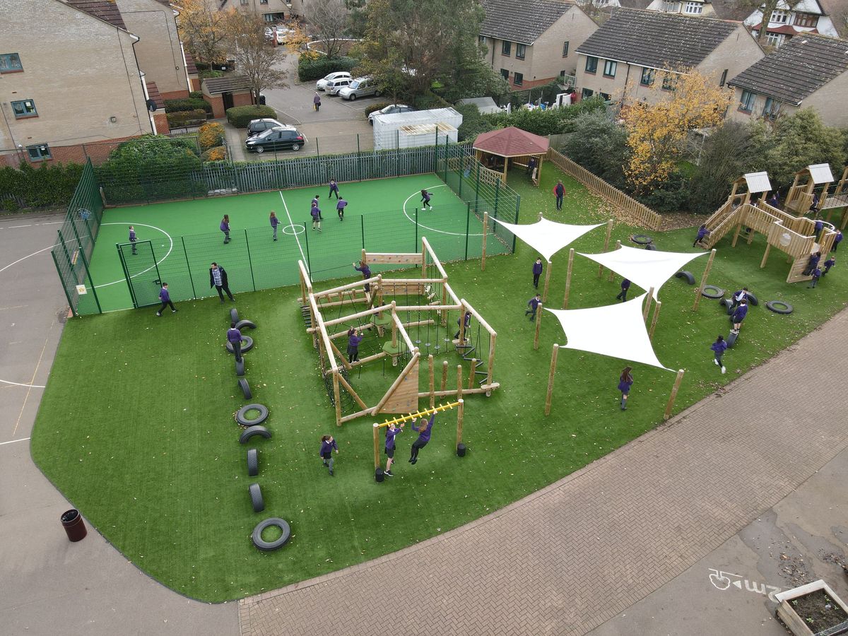 A playground that contains a MUGA, a variety of play equipment and 3 sail shades, providing a lot of resources for children to engage with.
