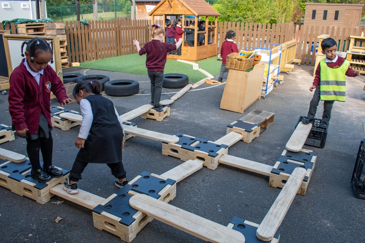 A group of children are navigating their way around a play builder obstacle course.