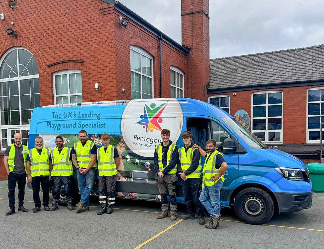 A Pentagon Play team of installers are stood beside the branded van and are smiling at the camera.