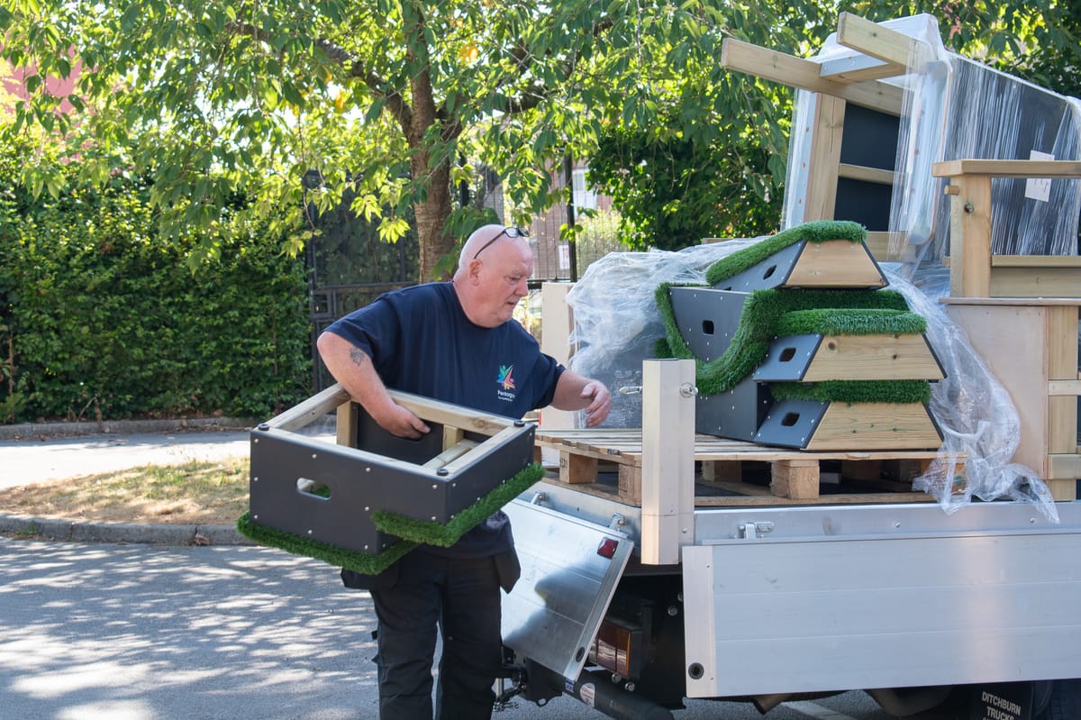 A Pentagon Play employee taking equipment off the back of a track.