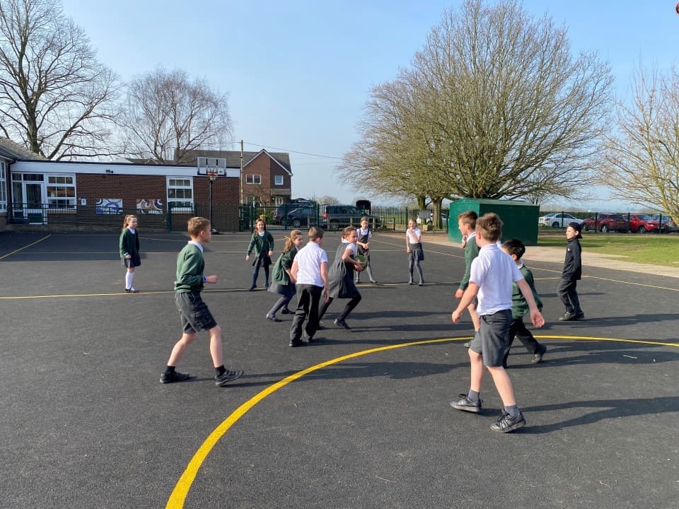 children play on the basketball court online on a wetpour surfacing