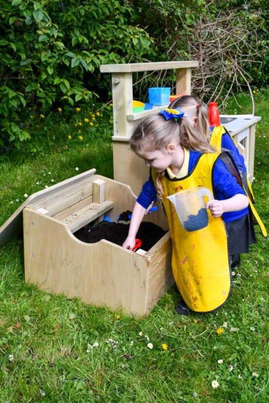 A child digging mud out of the mud box 