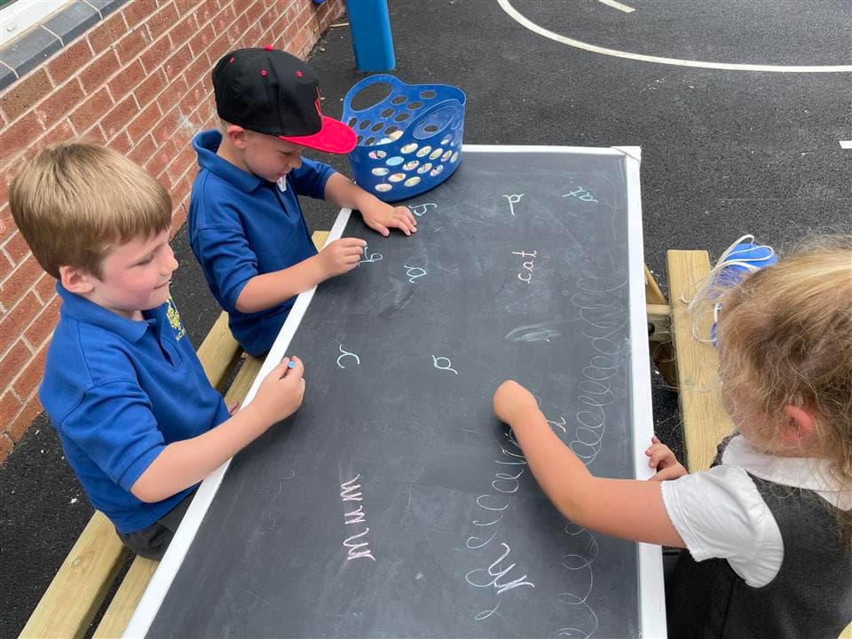 children playing on our picnic table with chalk board