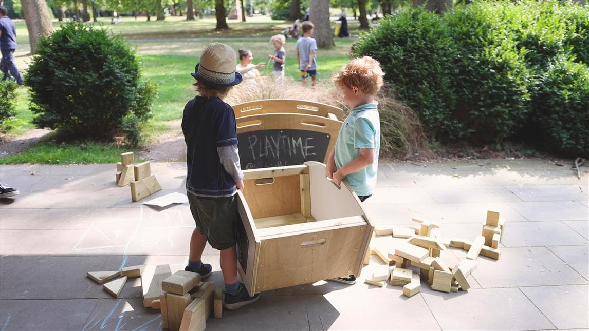 2 young boys carrying the mini skip
