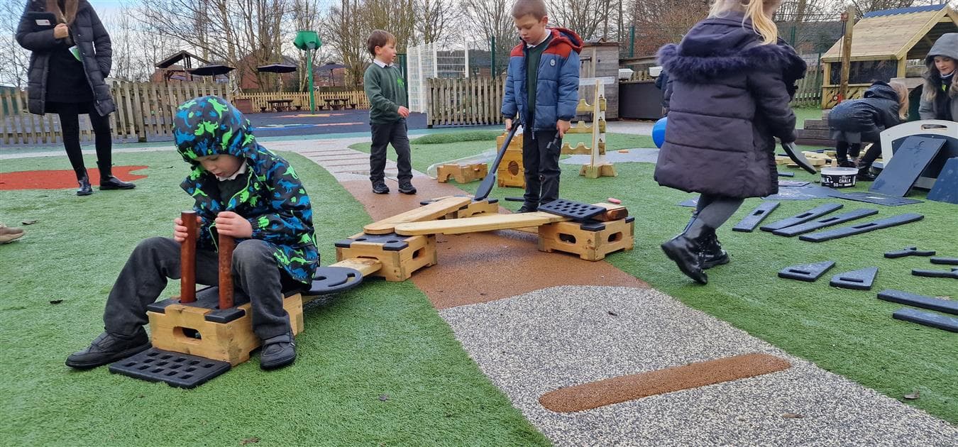 A young boy pretending to drive a train in his playground