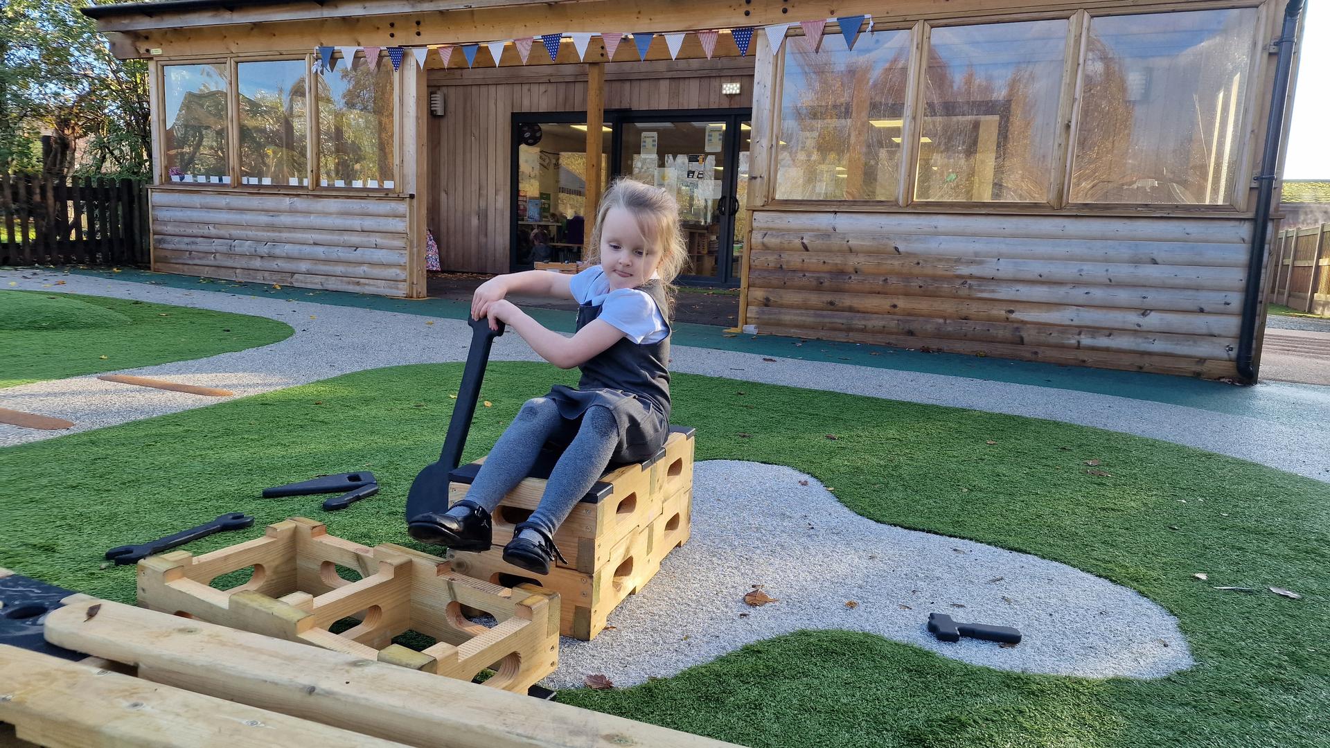 A young girl using a paddle as a role play boat