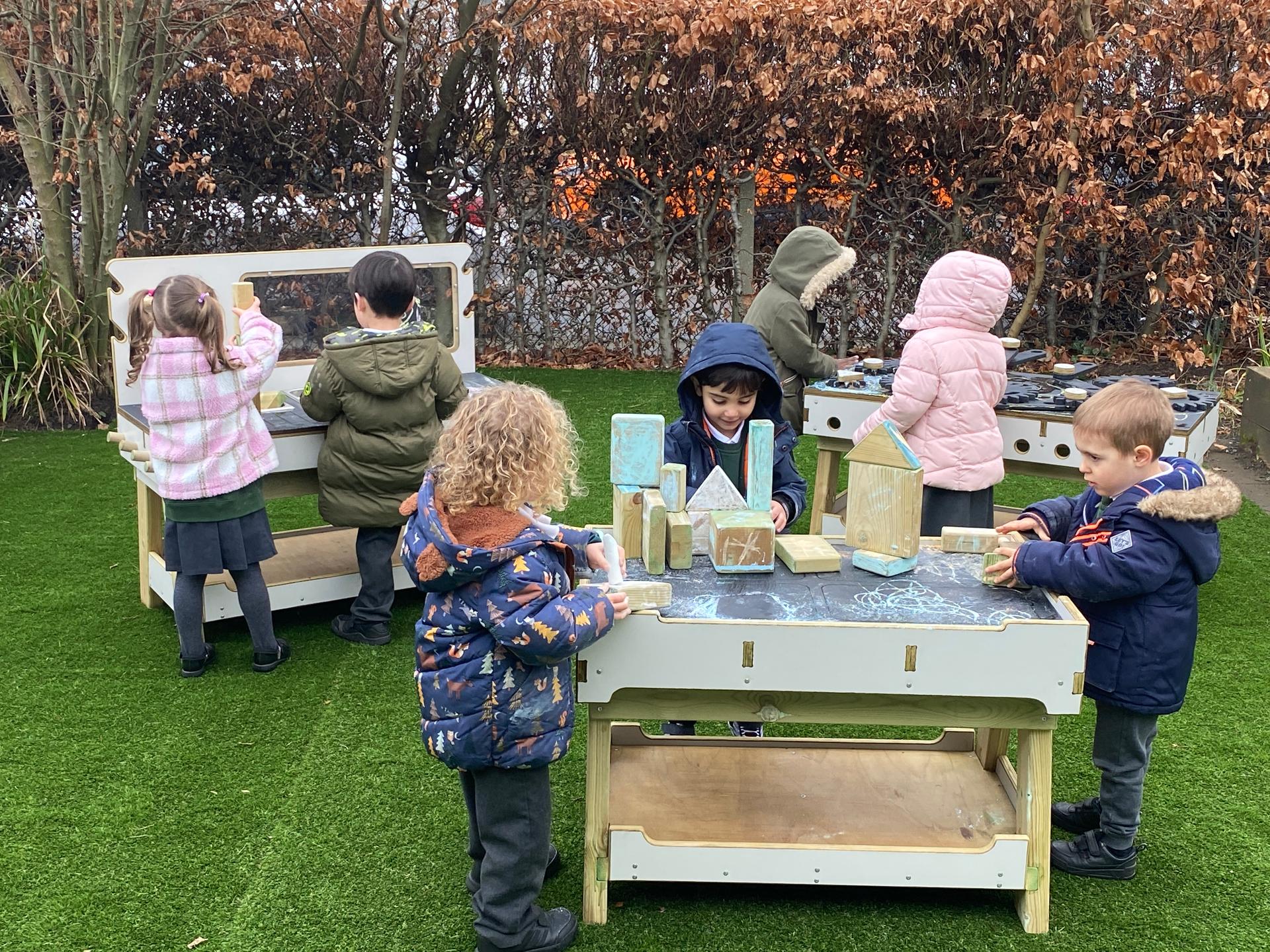 A class of children playing on the construction play area