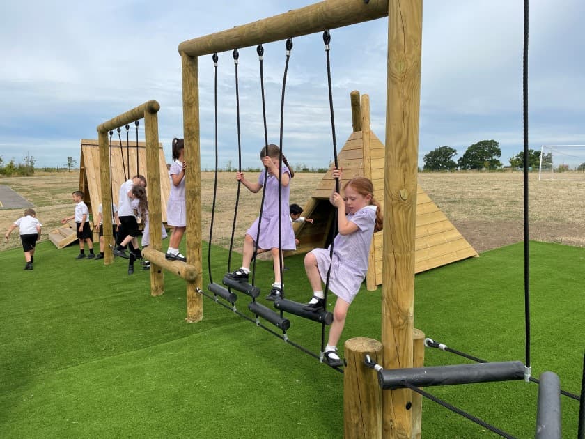 A class of ks1 children climbing on the forest trim trail 