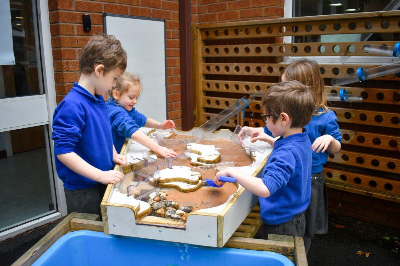 a group of children playing with the damming station