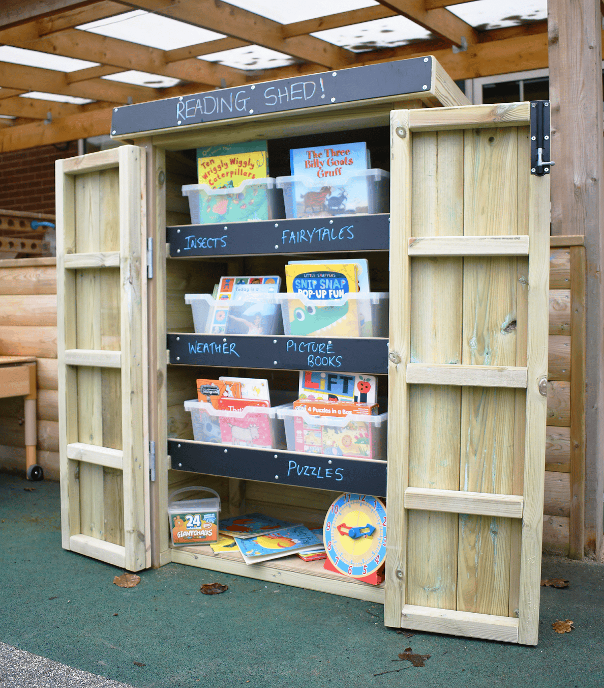 Open Wooden Acorn Storage Unit with books inside, in a school playground