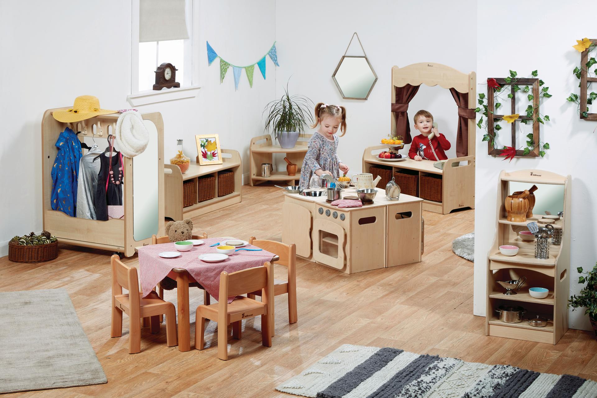 A young girl and boy play different games in the Under 3's Role Play Zone inside a classroom.