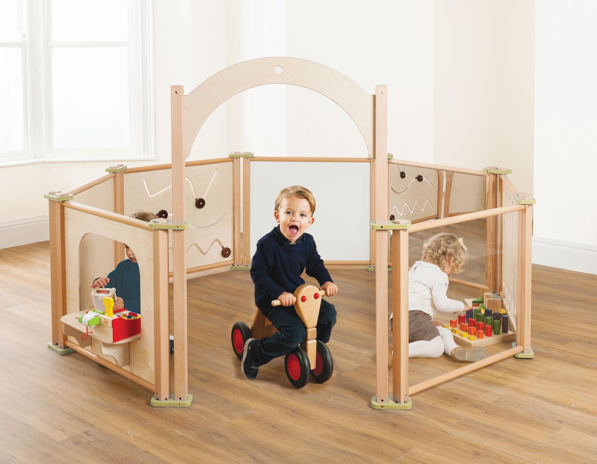 The Toddler Play Panel Starter Set - Enclosure 8 Panel Set has been set up in a classroom with three young children playing inside the enclosure. 