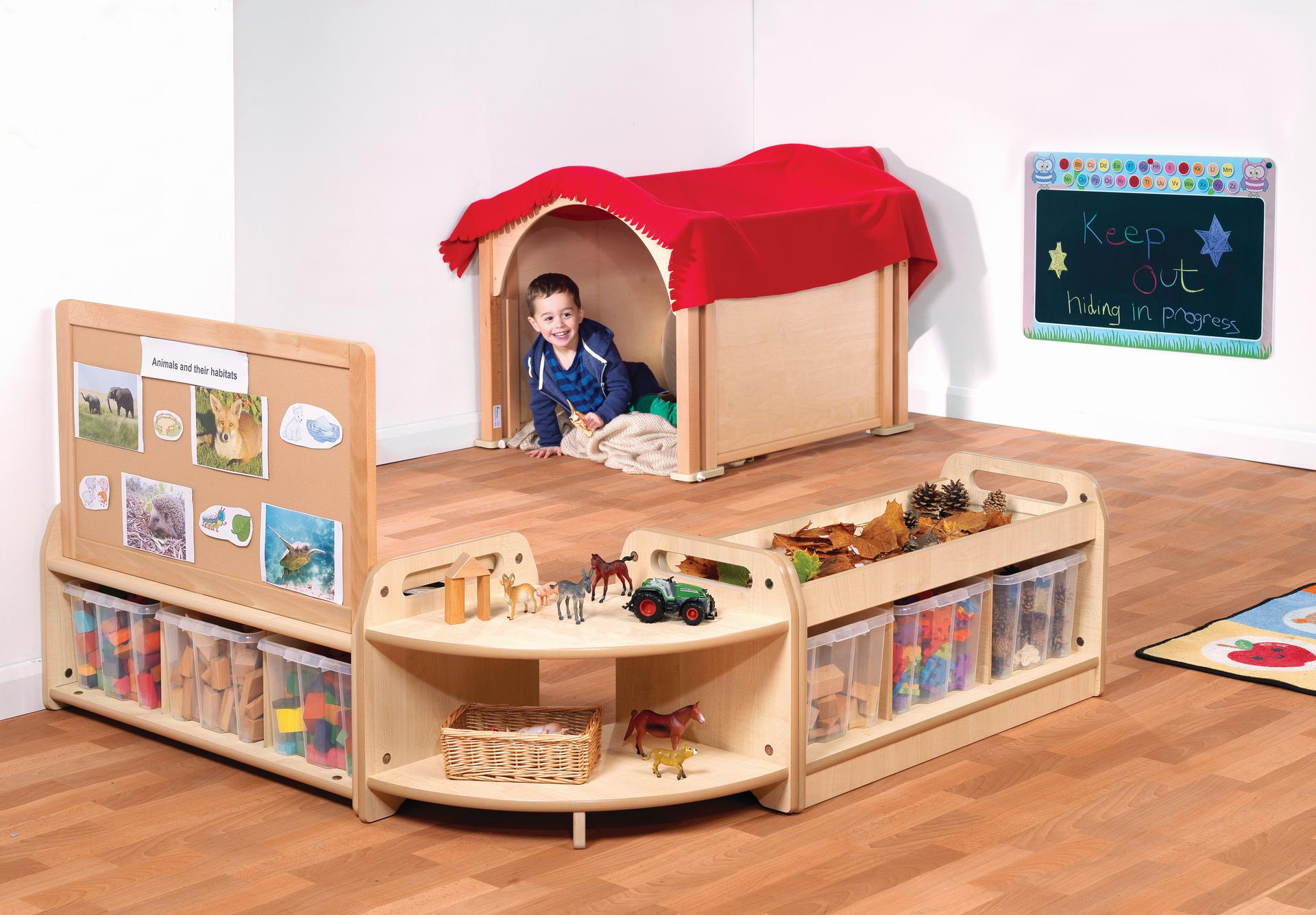 A young boy is hiding in the den which is part of Mini Hide and Seek Zone.