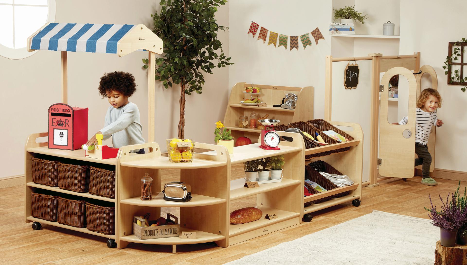 Two boys are playing shops inside the Role Play Zone inside a classroom. 