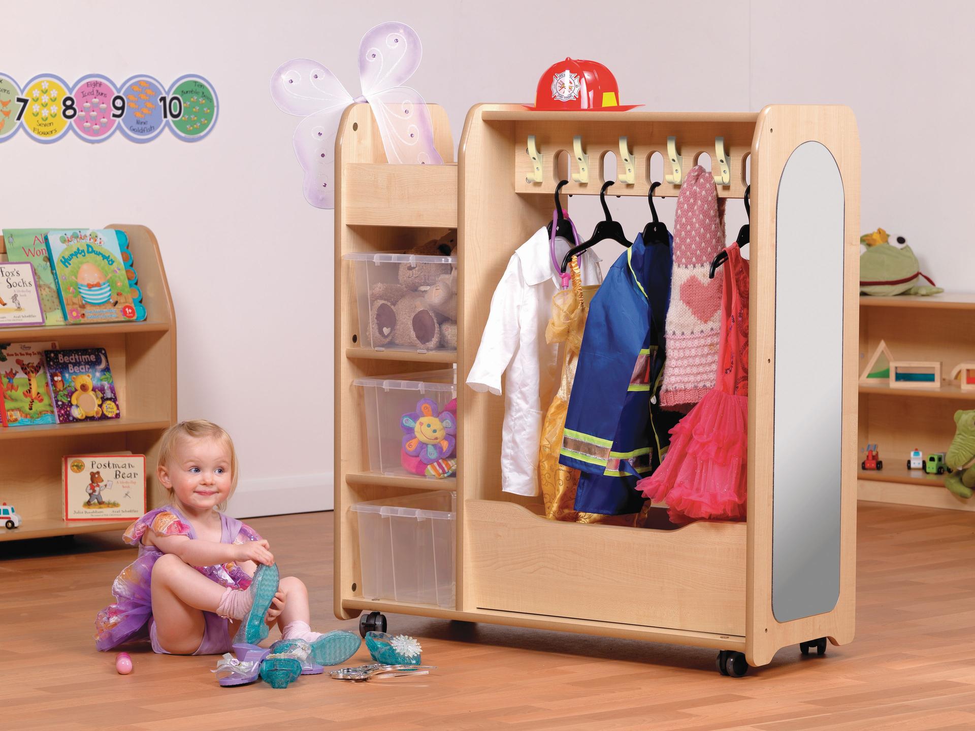 The Mobile Dressing Up Trolley is in a classroom with various different outfits hung up on it.