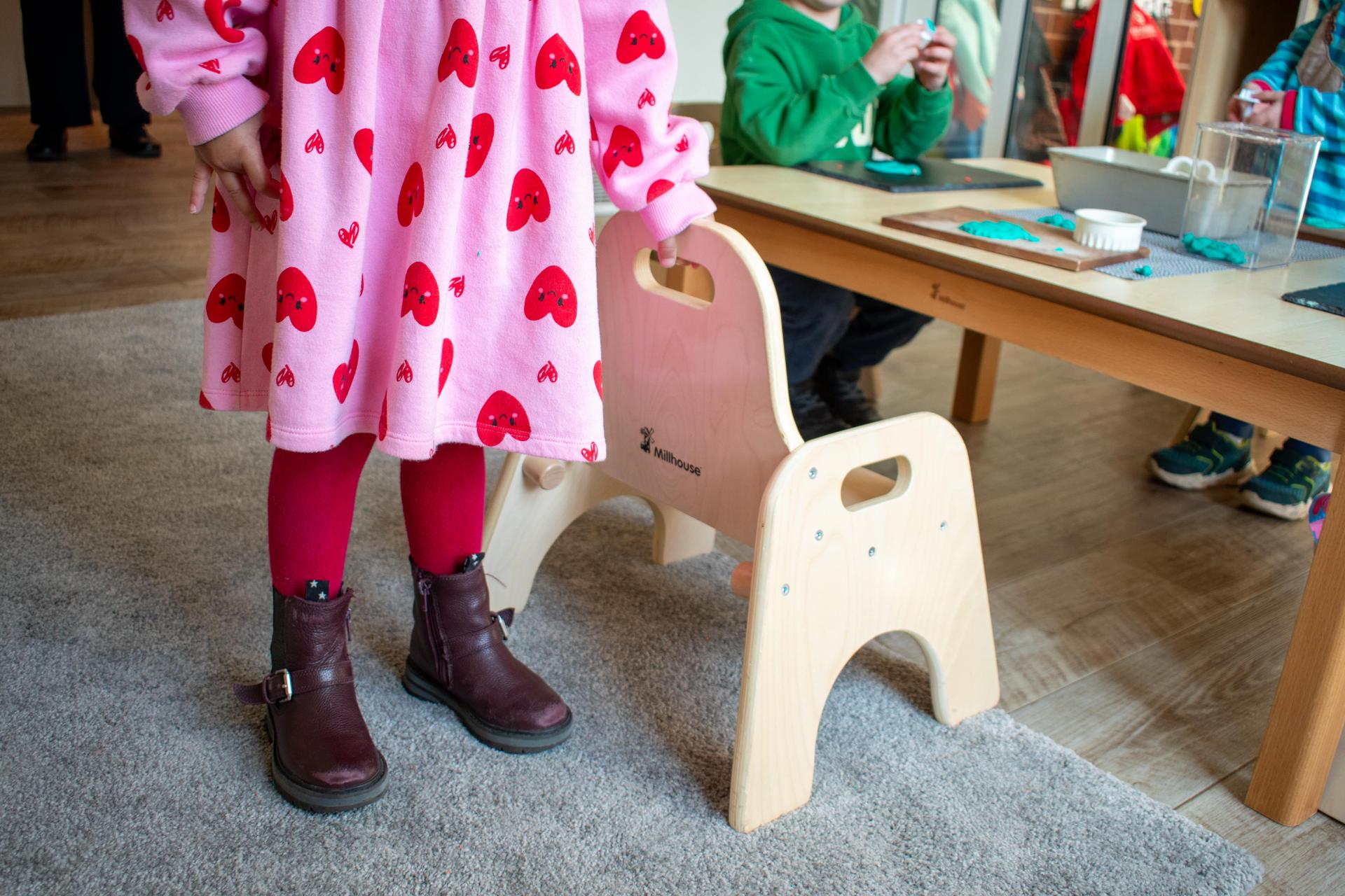 child holding millhouse sturdy chair against a millhouse table
