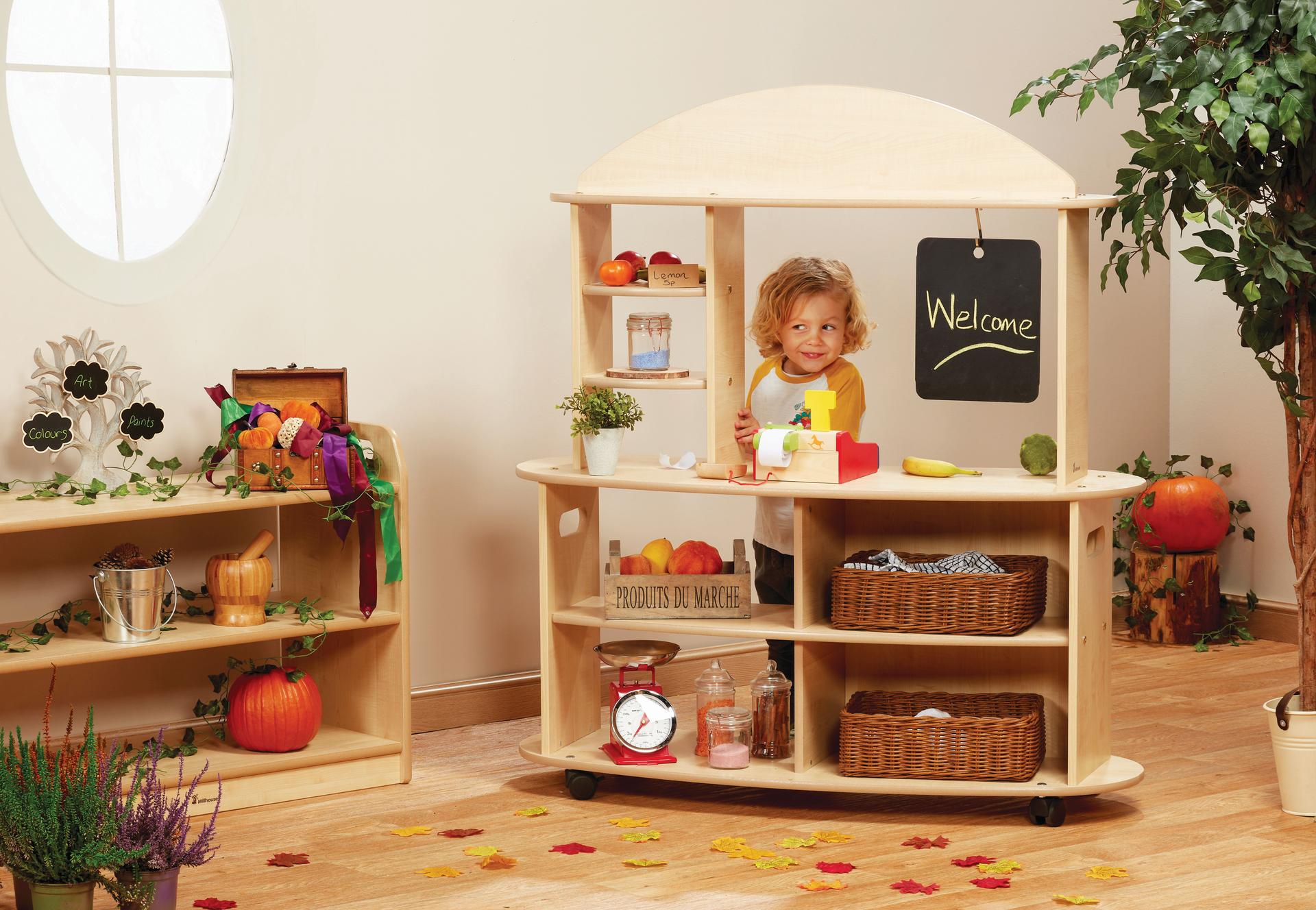 A young boy is playing shops with the Mobile Market in a classroom  