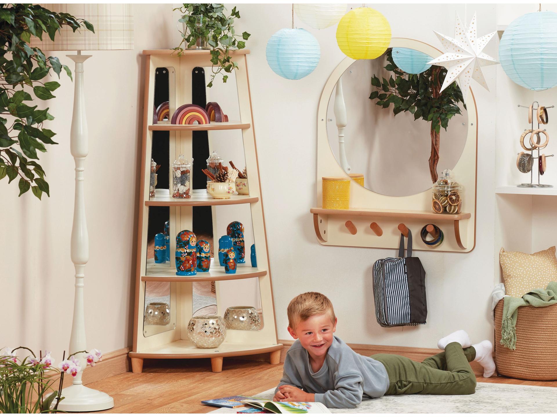 millhouse corner shelving unit in an eyfs setting with trinkets filling each shelf and a child reading in front