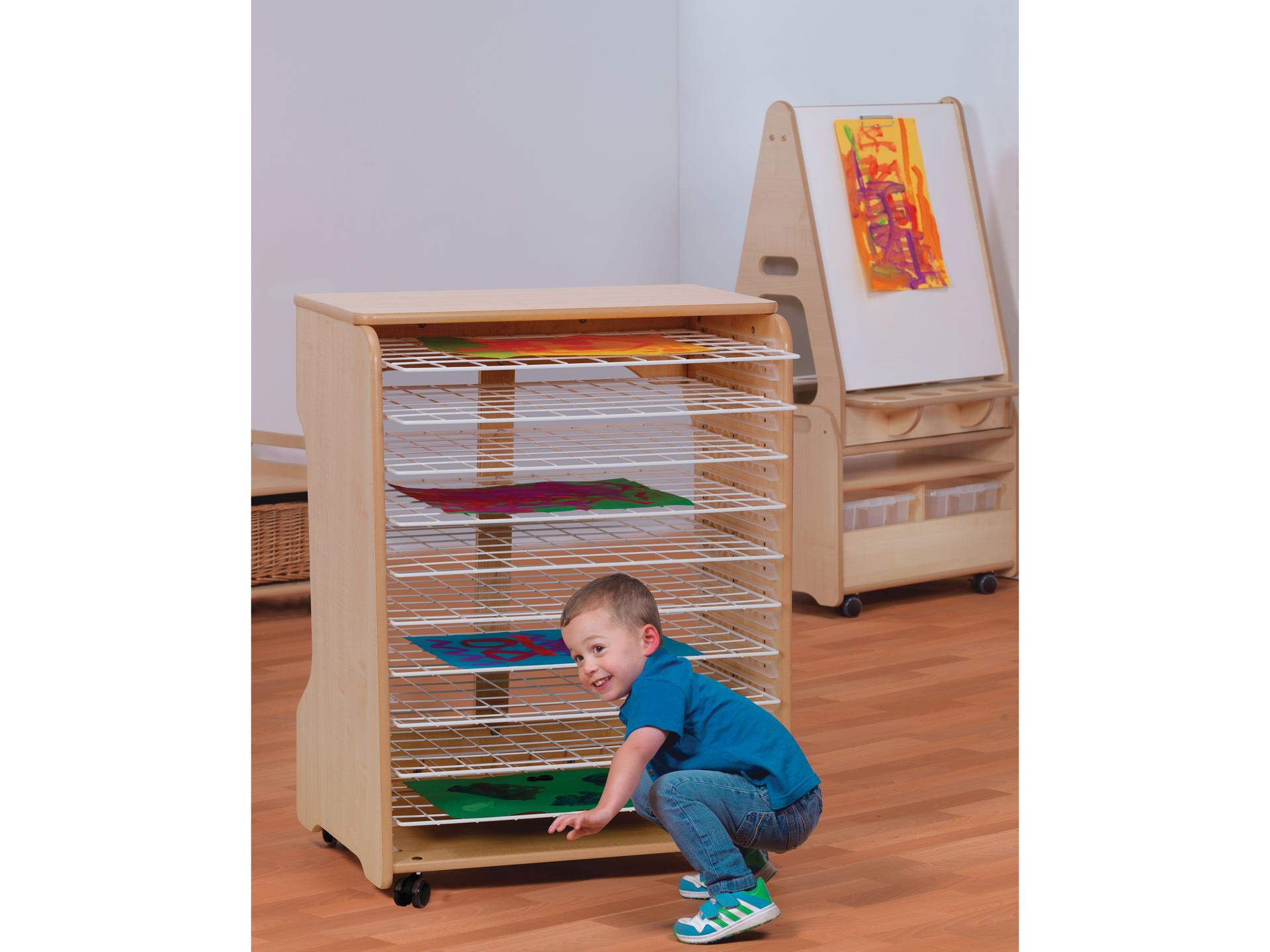 millhouse drying rack in a nursery room with child placing their artwork onto a rack