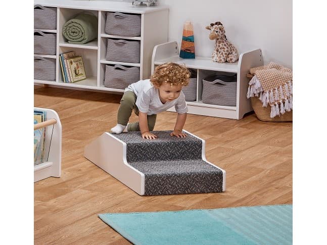 millhouse indoor baby stepped unit in white with carpet top and child crawling