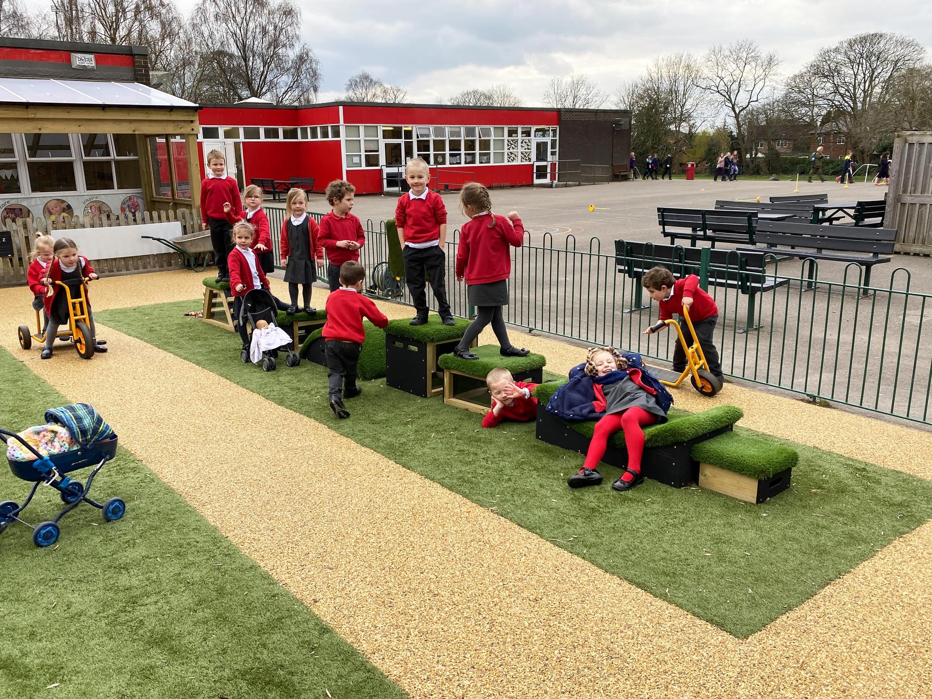Children moving across grass topped blocks 