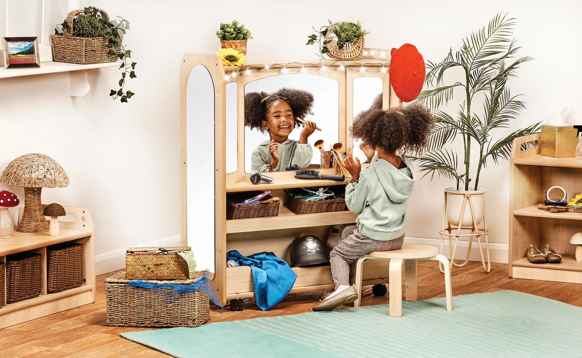 Low station with hooks, shelves, and a mirror. Children can hang costumes and play dress-up.