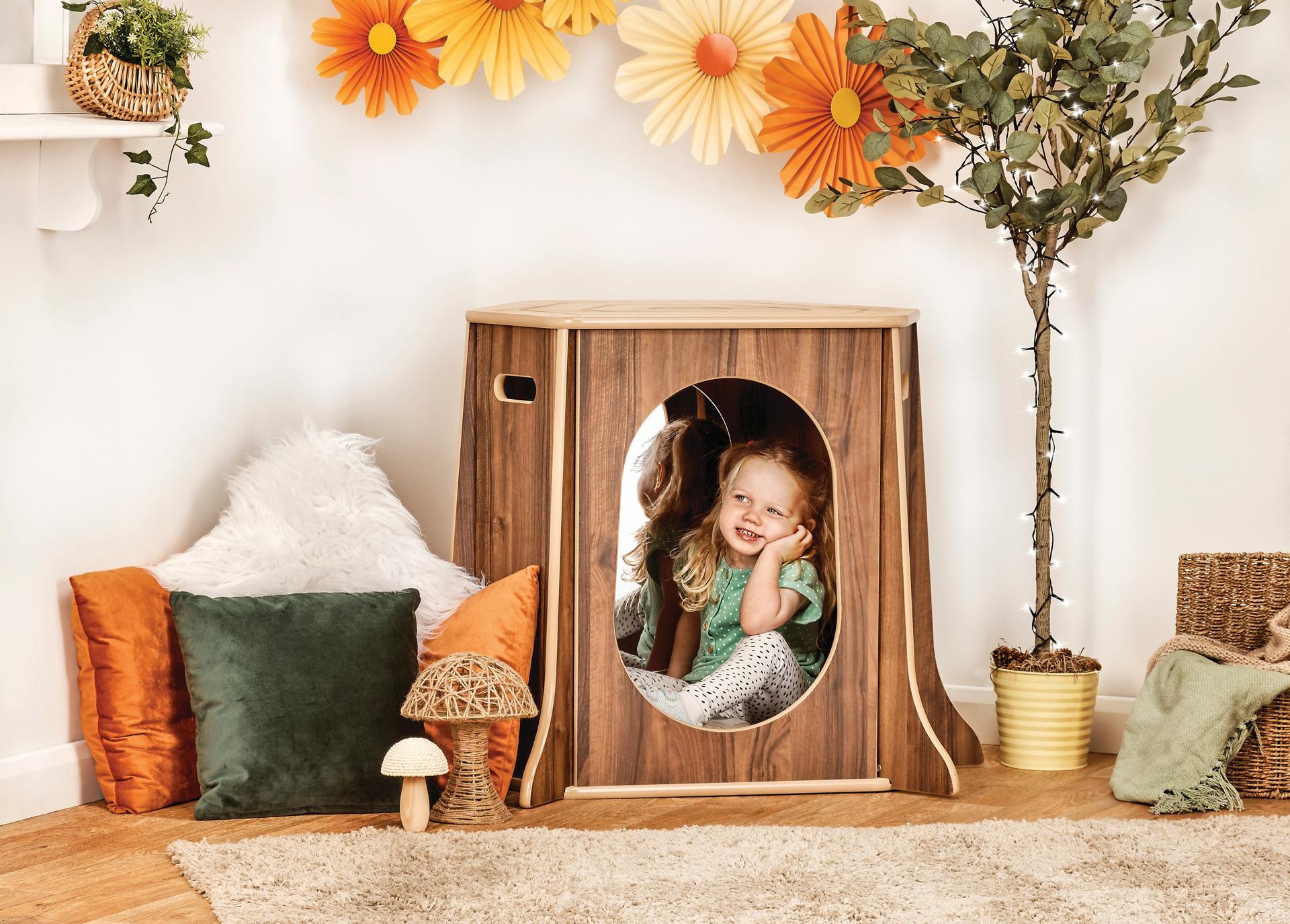 Small corner space shaped like a hollow tree. Cozy for reading or quiet play.