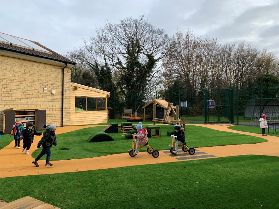 children go around on the scooter on the wetpour roadway