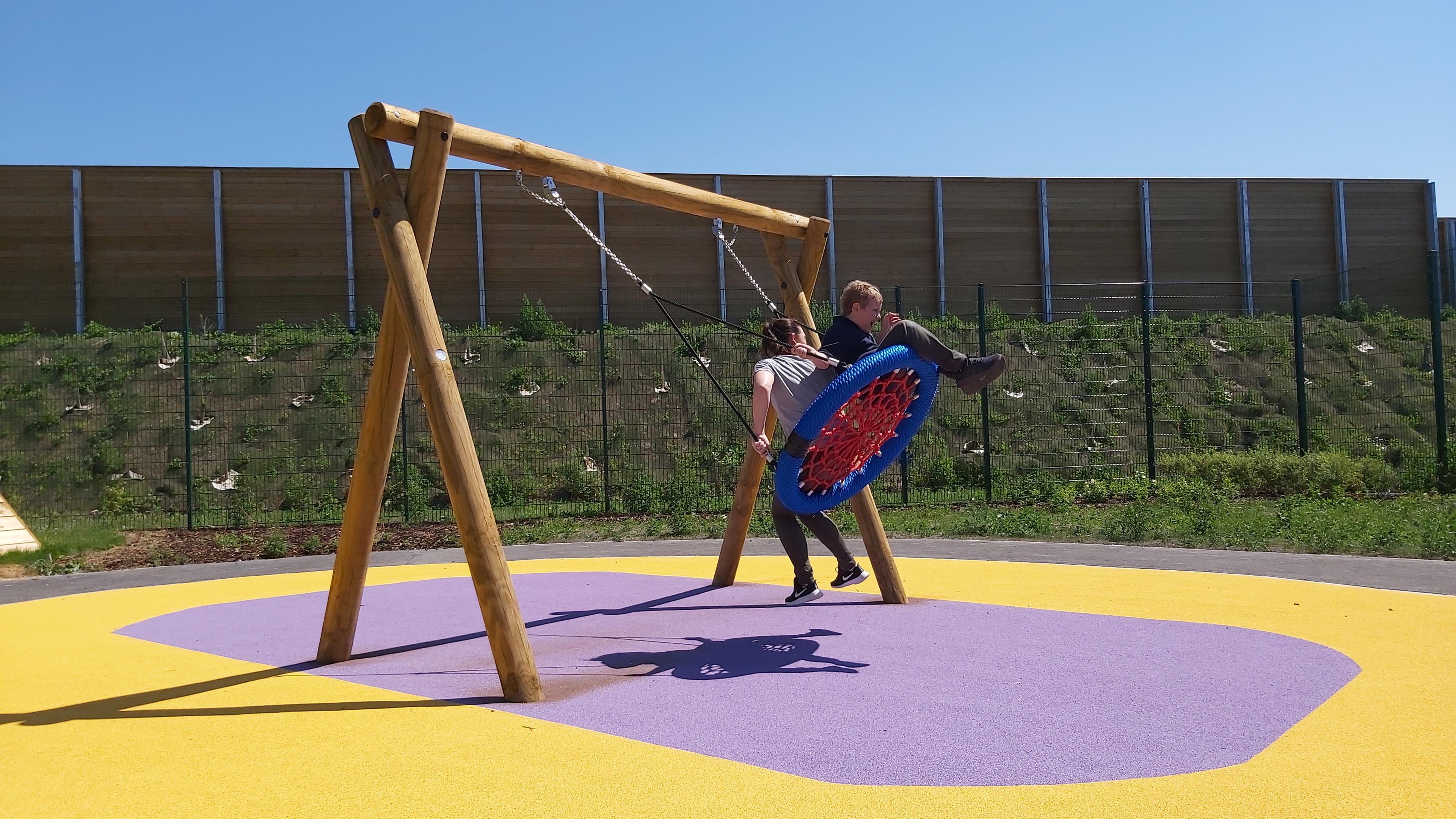 a child playing on timber swing