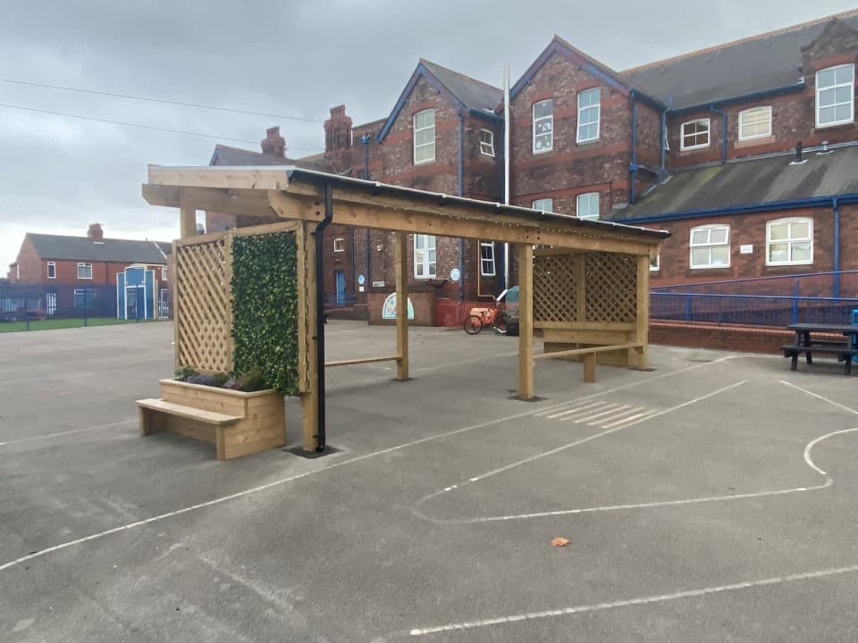 a freestanding timber canopy with trellis sides and a planter