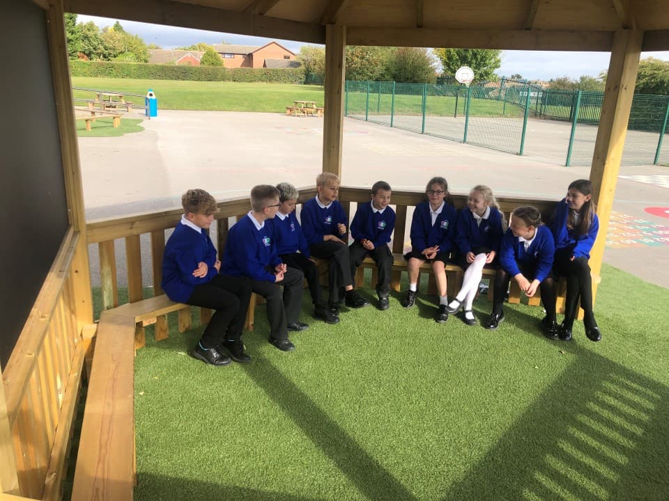 children gathered in the gazebo being used as an outdoor classroom