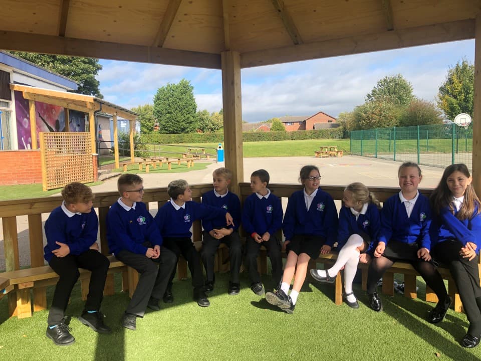 gazebo being used as an outdoor classroom as children gather inside for a lesson