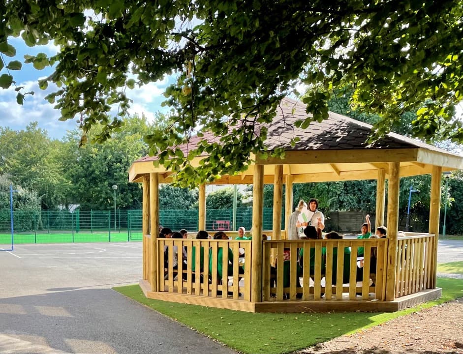 gazebo with sides on real grass with children sat in side
