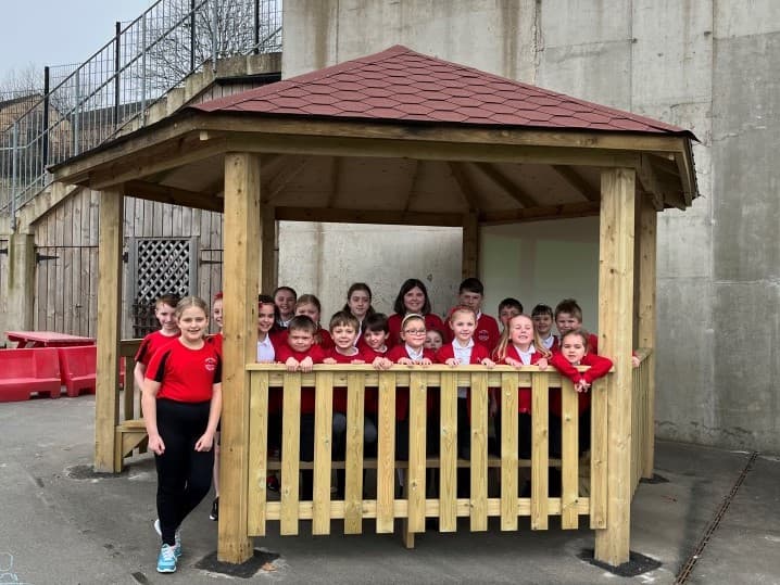 children stand inside the hexagonal gazebo