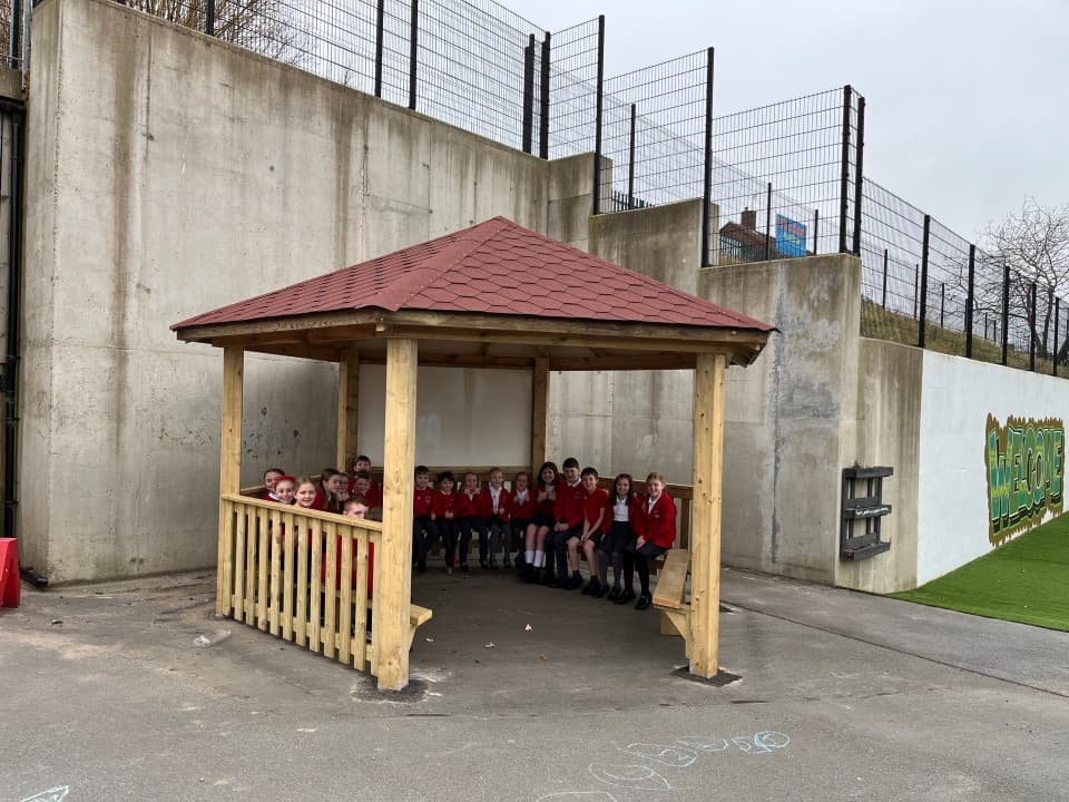 children sit in the hexagonal gazebo
