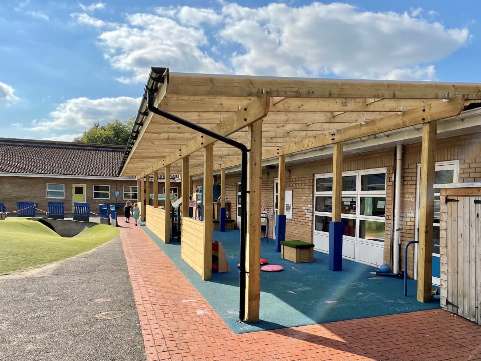 a timber canopy extending from a classroom