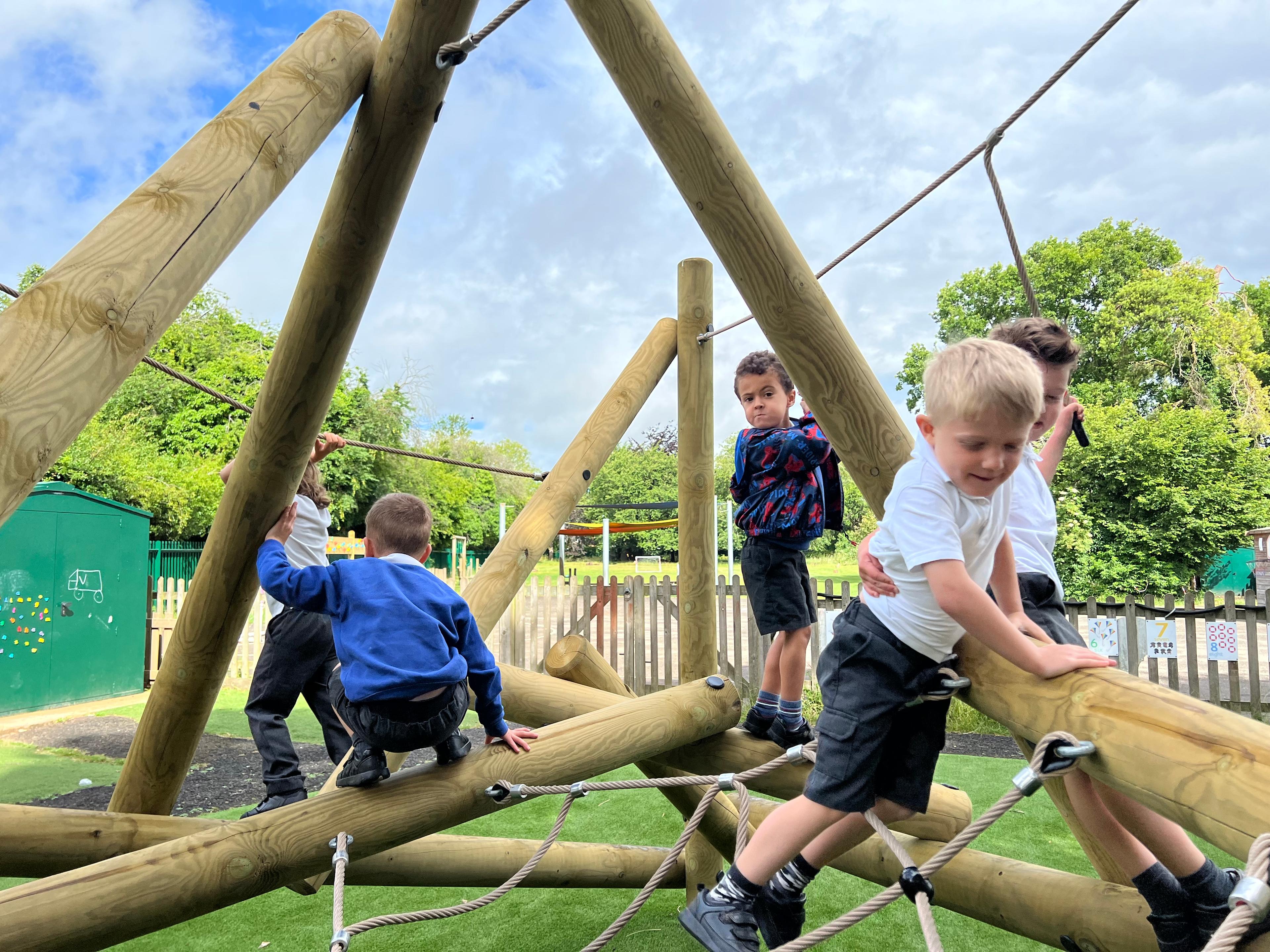A close up of a class of children on the climbing frame at their school