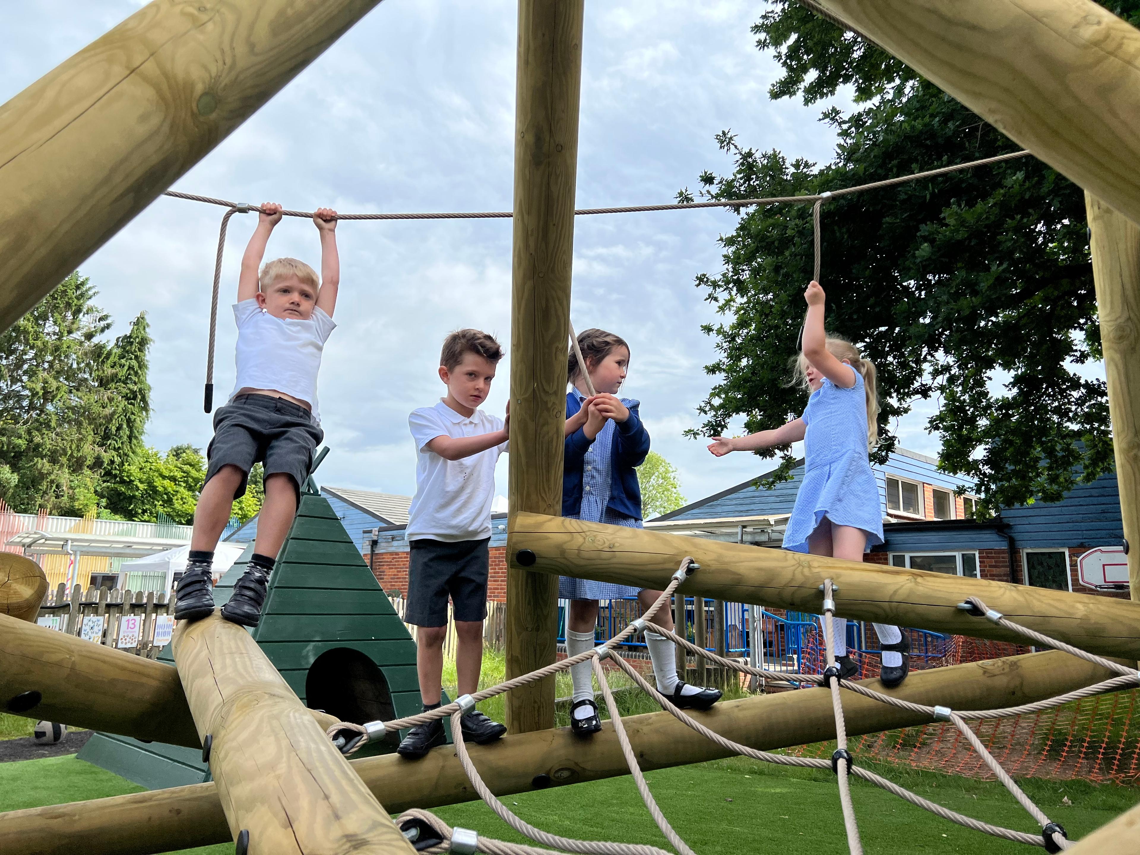 Pupils climbing on their large climbing frame at their primary school