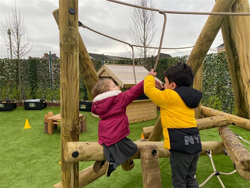 2 children playing on the school climbing frame