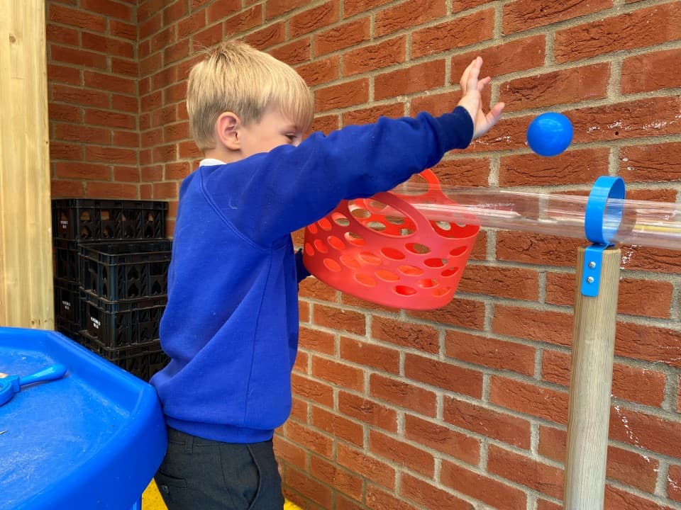 a child pours water down the water channel stands
