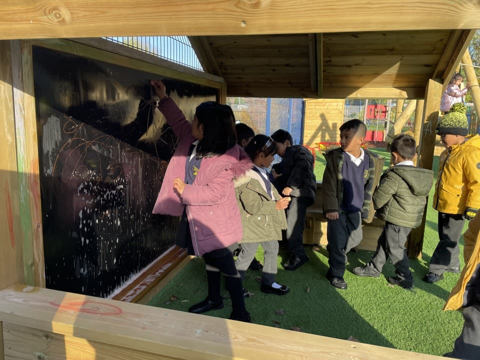 a timber playhouse with a chalkboard inside