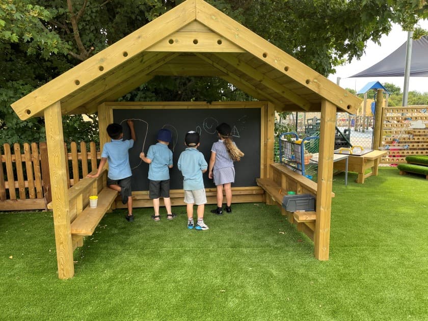 children doodle on the chalkboard in the giant playhouse