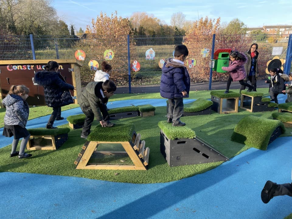 children play on the mendips set running around with playturf and blue wetpour surfacing below