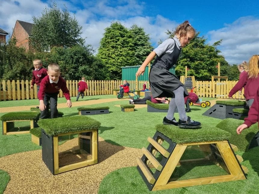 A class of key stage 1 children jumping across the movable blocks