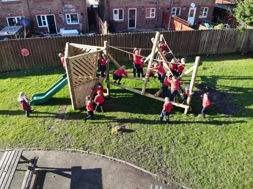 Wooden Bowfell Climbing Frame with Platform and Slide in school playground.