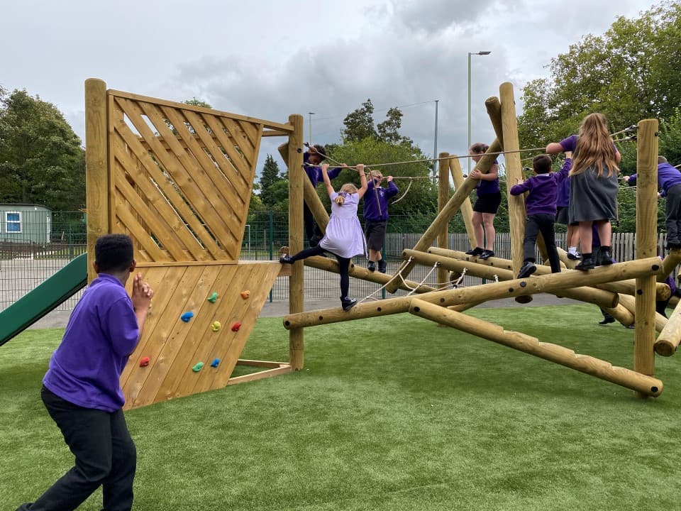 a side view of children climbing on the climbing frame
