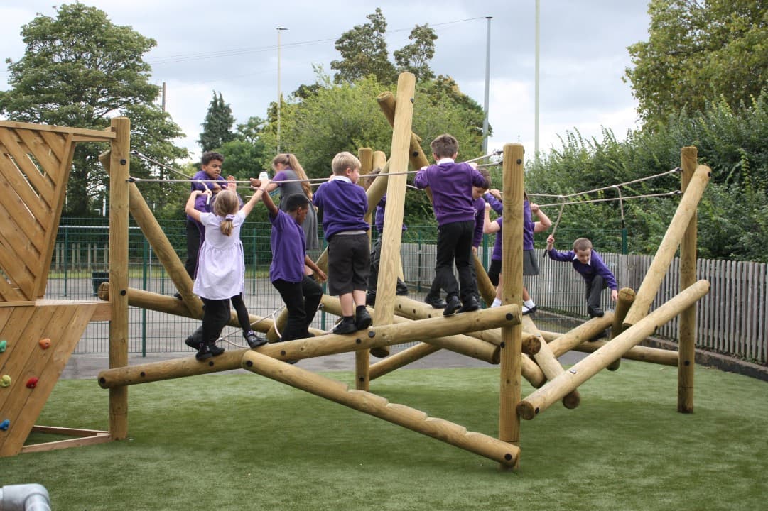 children pose on the harter climber frame as they climb
