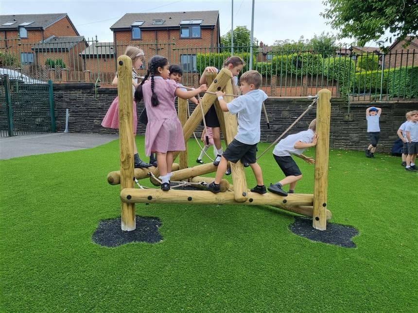 A group of children playing on the pinnacle climber at their primary school