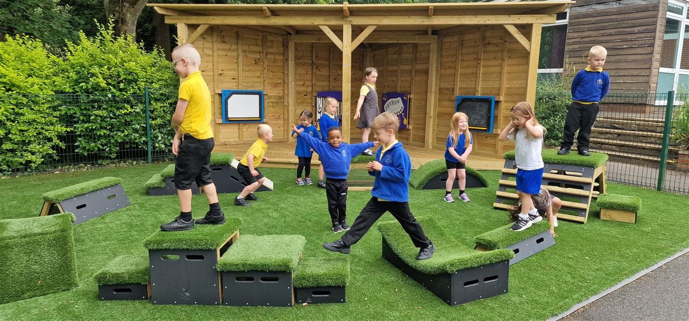 A class of children playing on the movable blocks in their early years playground