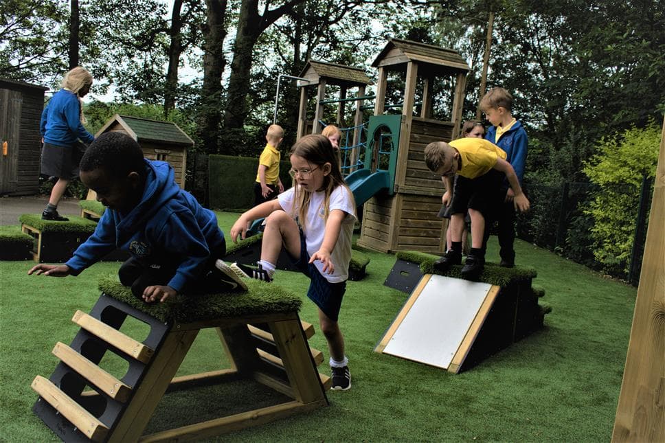 A group of children climbing up the movable blocks in their playground